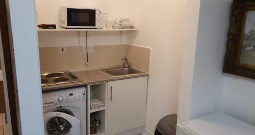 a kitchen with a microwave and a sink at Lovely studio flat in Margate