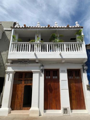 a white building with wooden doors and a balcony at Hotel Mangata in Cartagena de Indias