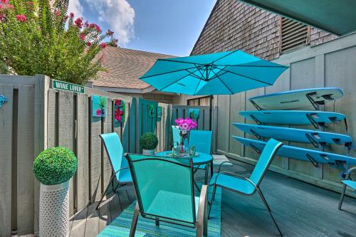 a patio with blue chairs and a table with a blue umbrella at Coastal Resort Beach Villa Less Than 1 Mi to Shore! in Hilton Head Island