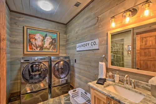 a bathroom with a washer and dryer next to a sink at Luxurious Mountain Getaway with Game Room and Hot Tub! in Mineral Bluff