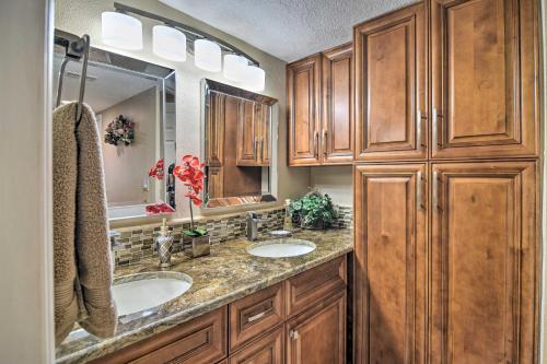 Un baño con dos lavabos y armarios de madera. en Beachfront Indian Shores Condo - Pool and Hot Tub!, en Clearwater Beach