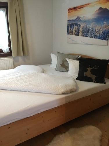 a bed with white sheets and pillows on it at Apart Larcher in Arzl im Pitztal