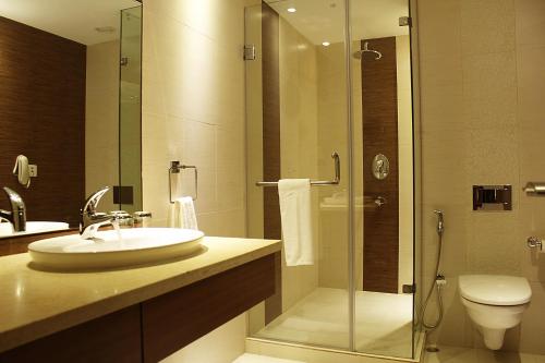 a bathroom with a sink and a glass shower at Celesta - Kolkata in Kolkata
