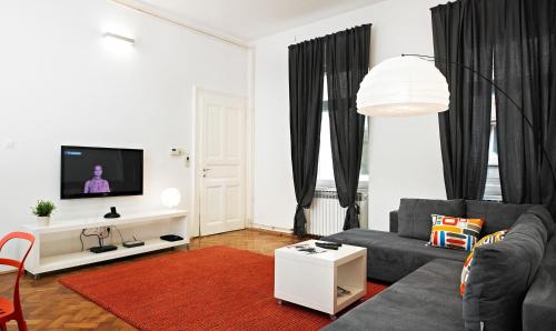 a living room with a couch and a tv at Irundo Downtown Apartments in Zagreb