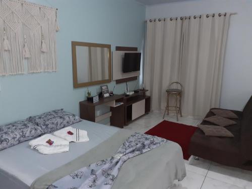 a hotel room with a bed and a chair at loft harmonia in Blumenau