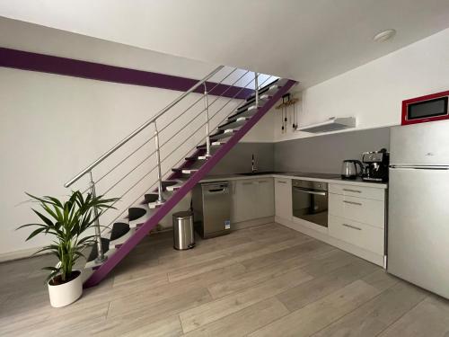 a kitchen with a purple staircase in a room at Le Soulier En Cévennes 4 étoiles in Saint-Martin-de-Valgalgues