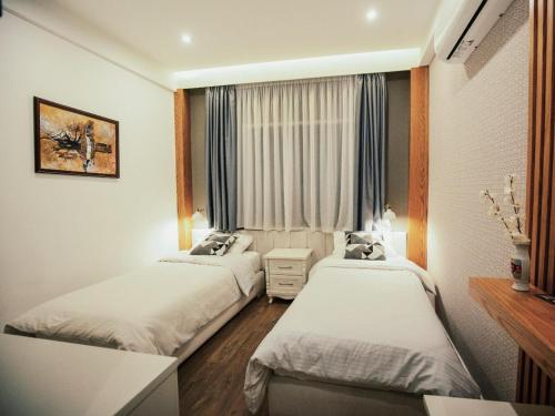 a hotel room with two beds and a window at Hotel Romeo in Korçë
