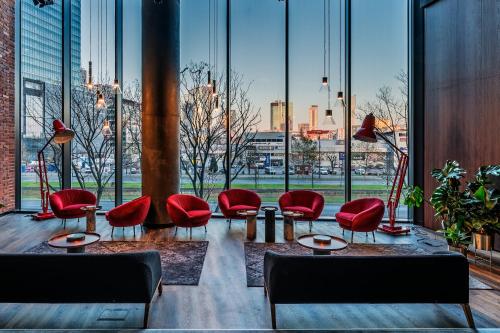 a lobby with red chairs and large windows at Crowne Plaza - Warsaw - The HUB by IHG in Warsaw