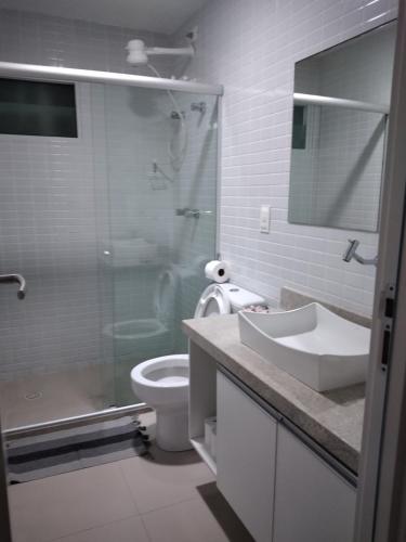 y baño con aseo, lavabo y ducha. en Apto Areias beira-mar en Barra de São Miguel