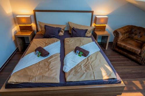a bedroom with a bed with two pillows and a chair at Seaside-Townhouse in Timmendorfer Strand