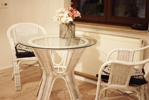 a glass table with a vase of flowers on it at Monteurwohnung Oyten bei Bremen A1 dat Landhuus in Oyten