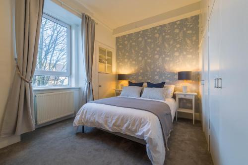 a bedroom with a bed and a window at Stylish and Comfortable City Centre Apartment in Edinburgh