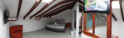 Habitación con cama en la esquina de una habitación en Hostal Villa Rosita en Villa de Leyva