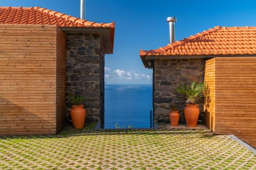 a house with two doors and potted plants at Villa Flora - Nature & Tranquility - Heated pool optional in Jardim do Mar