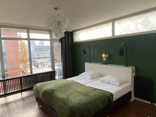 Un dormitorio con una cama grande con una pared verde. en Anno, en Almere