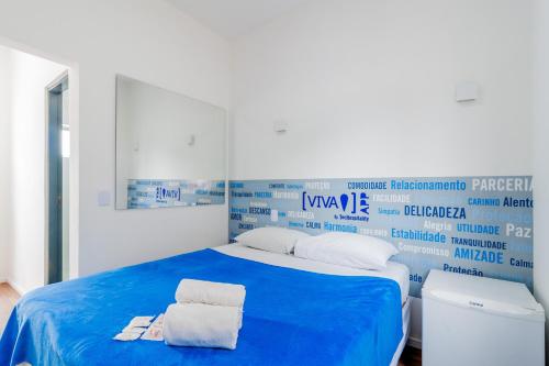 a bedroom with a blue bed with towels on it at Blue Ocean Suites - Aeroporto Congonhas in Sao Paulo