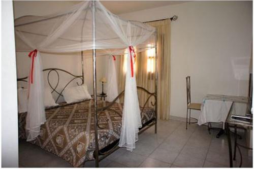 1 dormitorio con 1 cama con dosel en Villa Rosa en Dakar