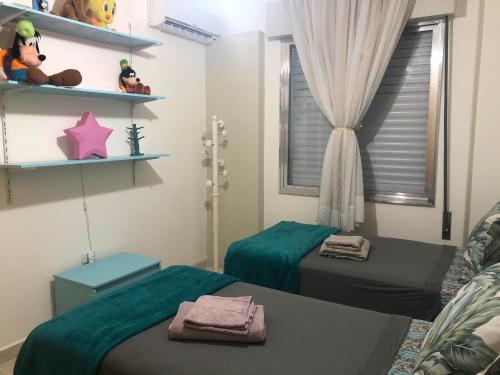 a room with two beds and a window and shelves at Apto. frente ao mar no Gonzaga - melhor localização! in Santos