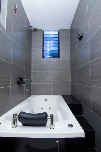 a bathroom with a bath tub and a window at Hotel California Calca in Calca