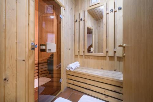 ein Holzbadezimmer mit einer Badewanne und einem Spiegel in der Unterkunft Villa Anna Luxury Lake Residence in Shtarkelovo Gnezdo