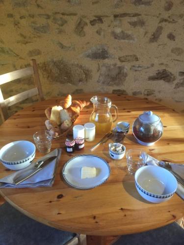 una mesa de madera con platos azules y blancos. en Domaine des Pierres Jumelles-balade à cheval-chambre d'hôtes Mayenne, en Sainte-Gemmes-le-Robert