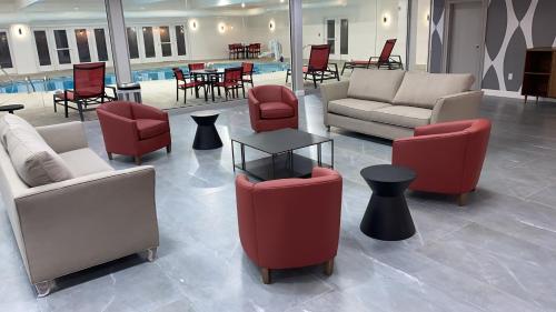 a lobby with couches and chairs and a table at Ramada by Wyndham Hartford North - Bradley Airport in Windsor Locks