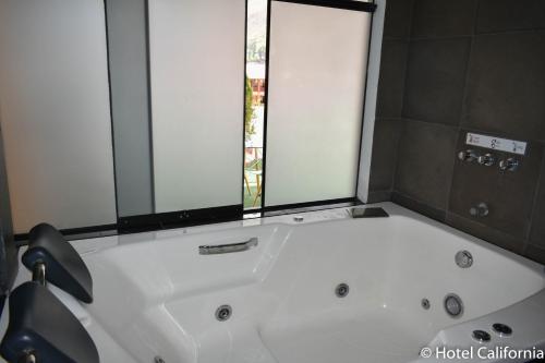 a white bath tub in a bathroom with a window at Hotel California Calca in Calca