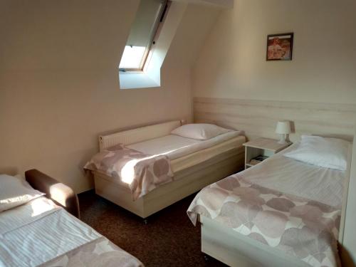 a bedroom with a bed, a desk and a window at Hotel Jester in Wrocław