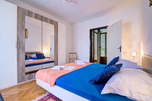 a bedroom with a large bed and a mirror at Apartments Diego in Sveti Juraj