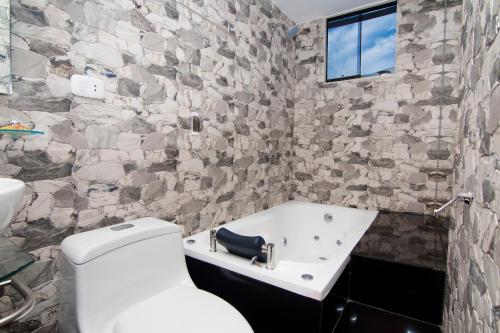 a bathroom with a white toilet and a sink at Hotel California Calca in Calca
