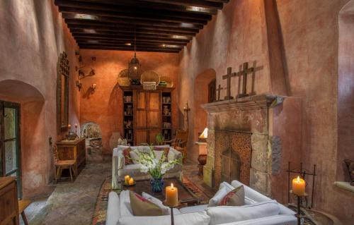 a living room with a fireplace and white couches at Hacienda Las Amantes in San Miguel de Allende
