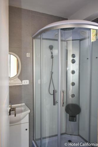 a shower with a glass enclosure in a bathroom at Hotel California Calca in Calca