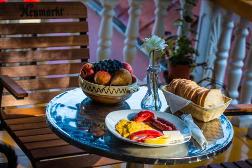 einen Tisch mit einem Teller Essen und einer Schale Obst in der Unterkunft Casa Albă in Baia de Aramă