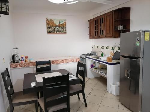 a kitchen with a table and a refrigerator at Departamento Boulevard MZO in Manzanillo