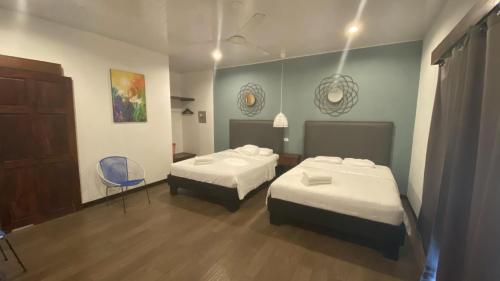 a room with two beds and a chair in it at La Posada Jungle Hotel in Manuel Antonio