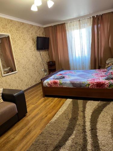 ウラジカフカスにあるКвартира посуточноのベッドルーム(ベッド1台、テレビ、ソファ付)