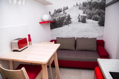 Snowland Apartmány في فالتشا: غرفة معيشة مع أريكة وطاولة