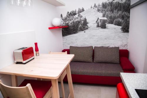 ein Wohnzimmer mit einem Sofa und einem Tisch in der Unterkunft Snowland Apartmány in Valča