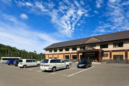 a parking lot with cars parked in front of a building at Kamihoroso in Kami-furano