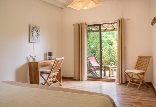 1 dormitorio con 1 cama, escritorio y sillas en La Maison Suites & Gastronomía, en La Paloma