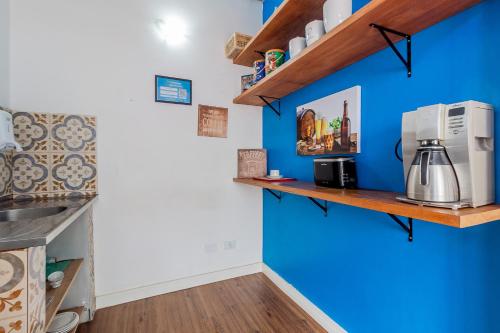eine Küche mit blauen Wänden und Holzregalen in der Unterkunft Club Suites - Aeroporto Congonhas in São Paulo