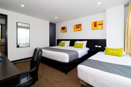 a hotel room with two beds and a desk at Ayenda 1063 Golden in Bogotá