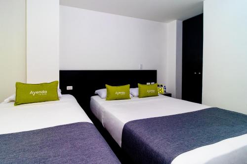 two beds sitting next to each other in a bedroom at Ayenda 1063 Golden in Bogot&aacute;