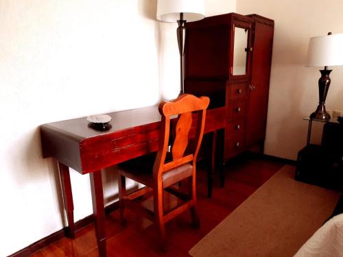 a desk with a chair and a cabinet in a room at Hotel Boutique La Albertina in San Martín Texmelucan de Labastida