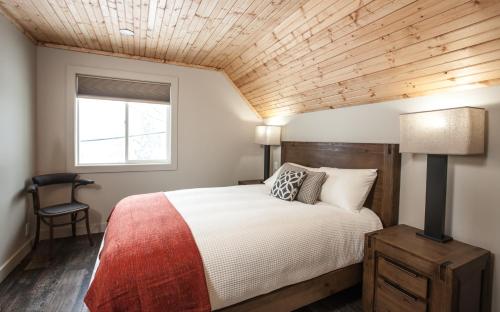 a bedroom with a bed with a wooden ceiling at Boulder Mountain Resort in Revelstoke