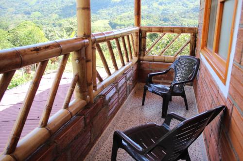 two chairs on a balcony with a view of the mountains at Finca Hotel Betel in San Carlos