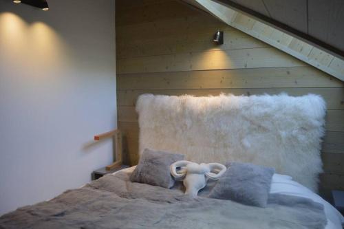 una camera con un letto con cuscini e un elefante sopra di Le lodge des Cîmes, Méribel Centre, Magnifique duplex cosy a Méribel