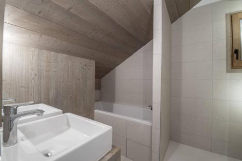 un bagno con lavandino e vasca da bagno di Le lodge des Cîmes, Méribel Centre, Magnifique duplex cosy a Méribel