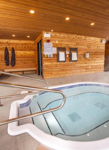 a hot tub in a room with a wooden wall at Boulder Mountain Resort in Revelstoke