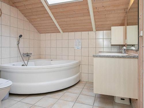 La salle de bains est pourvue d'une baignoire, de toilettes et d'un lavabo. dans l'établissement Four-Bedroom Holiday home in Væggerløse 8, à Bøtø By